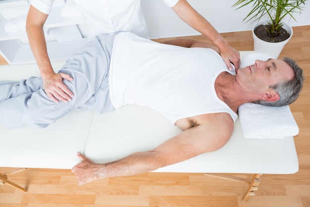 Photo physiothérapeute faisant massage des jambes à son patient