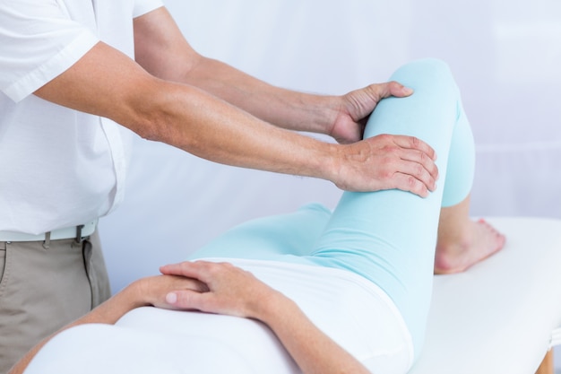 Physiothérapeute faisant massage des jambes à son patient