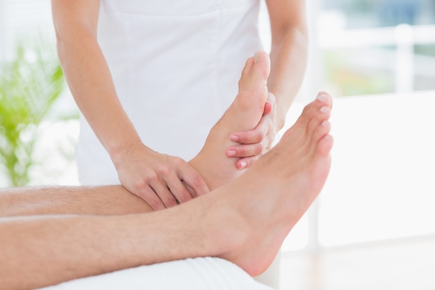 Physiothérapeute faisant massage des pieds