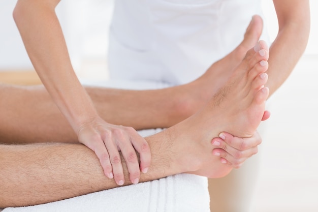 Physiothérapeute faisant massage des pieds