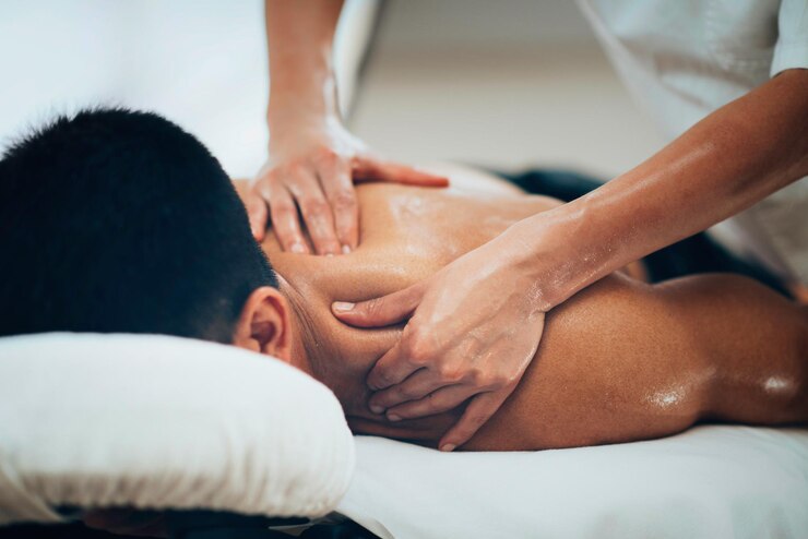Photo un physiothérapeute fait un massage de l'épaule d'un homme.