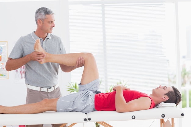 Physiothérapeute Fait Un Massage Des Jambes à Son Patient