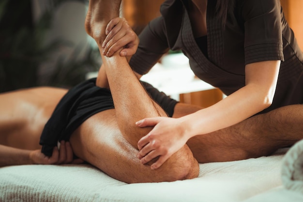 Physiothérapeute massant un patient masculin avec un muscle de la jambe blessé Traitement des blessures sportives