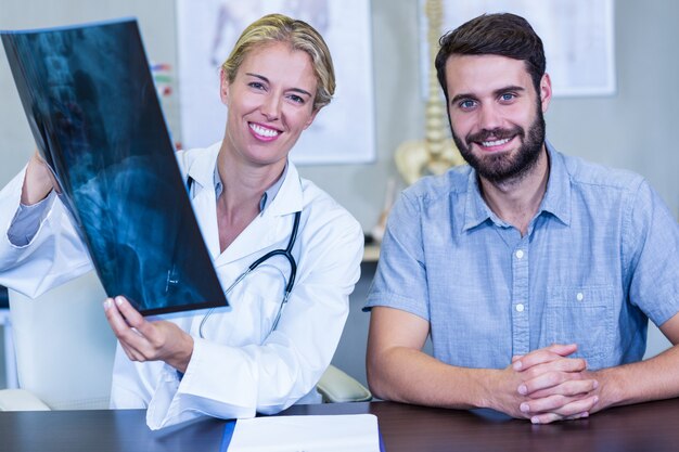 Physiothérapeute montrant des rayons x à un patient