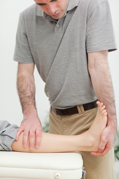 Physiothérapeute sérieux étirement de la jambe d&#39;un patient