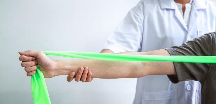 Physiothérapeute traitant le bras blessé d'un homme