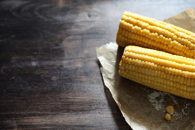 Épi de maïs bouilli avec du sel sur une table en bois