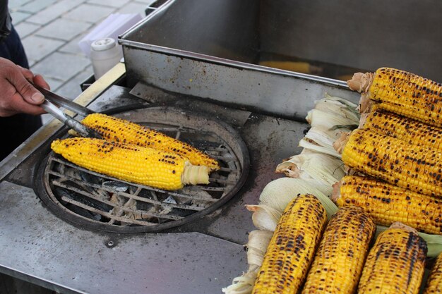 Épi de maïs grillé avec oignons sur le gril