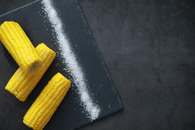 Épi de maïs parfumé fraîchement préparé avec du sel. Snack à la ferme de maïs frais. Petit-déjeuner sain et concept de mode de vie sain.