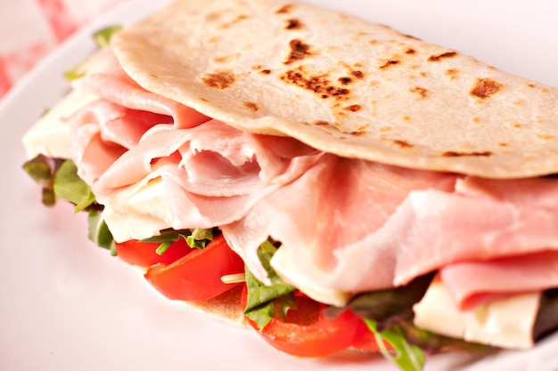 Piadina italienne traditionnelle avec jambon fromage tomate et salade