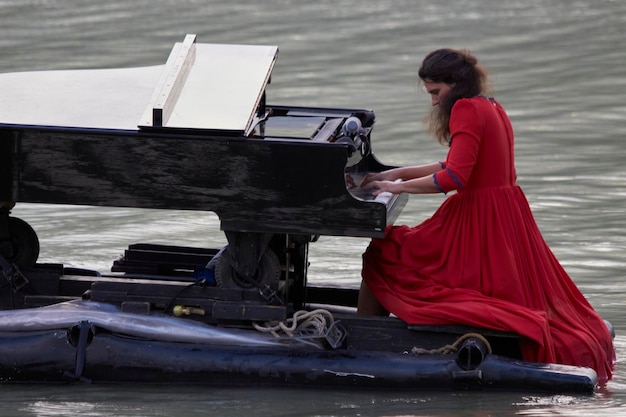 Pianiste jouant du piano au bord du lac