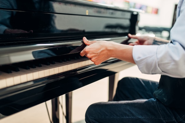 Le pianiste ouvre le couvercle du clavier du piano à queue