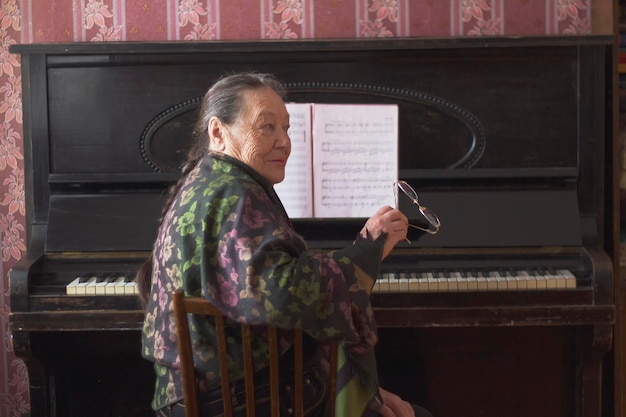 Pianiste de vieille dame assise au piano, vieillissement actif