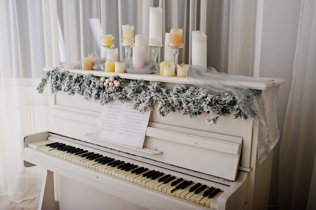 Piano blanc avec des bougies. Concept de joyeuses fêtes d'hiver.