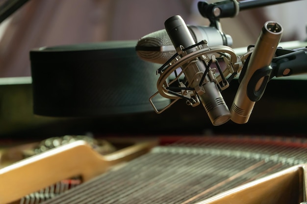 Un piano avec un couvercle ouvert Piano d'enregistrement jouant sur un microphone dans un studio d'enregistrement Grands microphones de studio