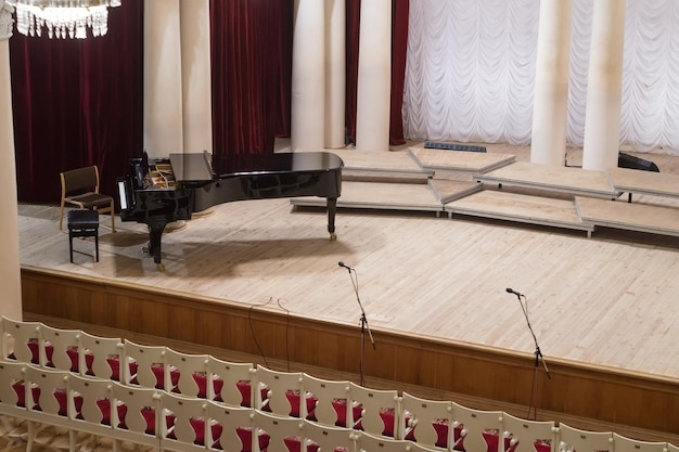 Piano sur scène et chaises vides dans l'auditorium de la salle de concert philharmonique