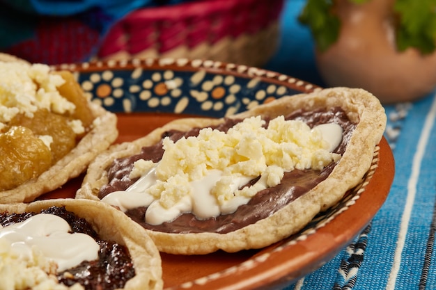 Picadas de frijol salsa de chicharron chili seco con crema y queso fresco comida mexicana