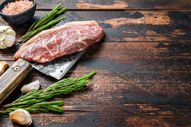 Picanha cru ou bifteck de haut de surlonge sur un couperet à viande.