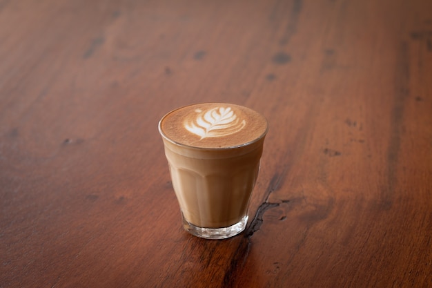 Piccolo Latte art dans un petit verre sur un bureau en bois