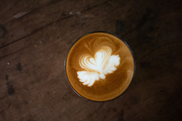 Piccolo Latte art dans une tasse en papier sur un bureau en bois