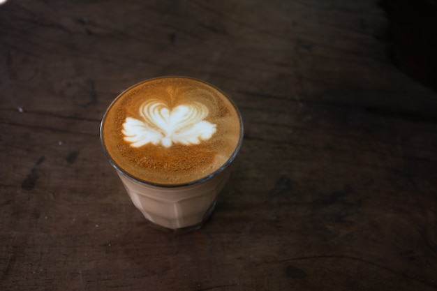 Piccolo Latte art dans une tasse en papier sur un bureau en bois