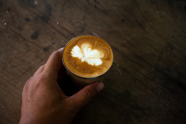 Piccolo Latte art dans une tasse en papier sur un bureau en bois