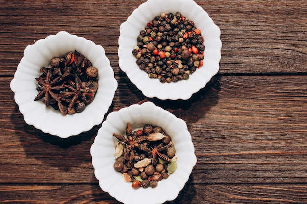 Épices anis poivre cumin cumin gingembre dans des bols sur une table en bois