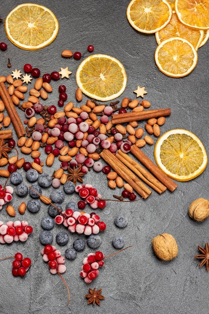 Épices de baies congelées et chips d'orange sur la table Fond noir