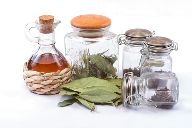 Épices de bouteille de vinaigre et feuille de laurier sur le blanc