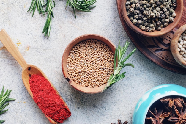 Épices et herbes indiennes colorées dans des bols sur une table en béton clair Concept de mode de vie sain