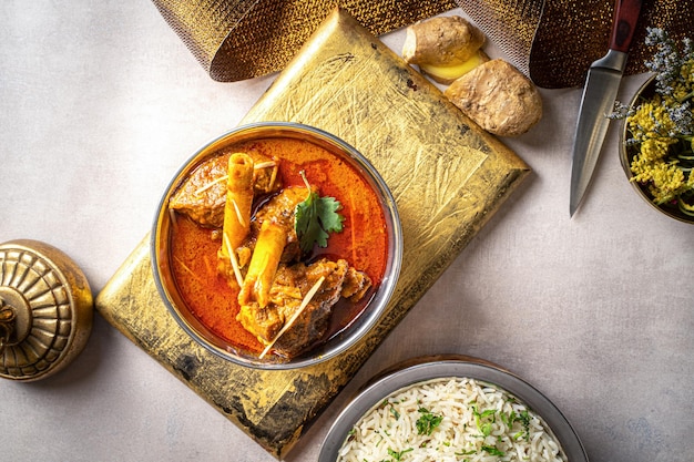 Épices indiennes Nalli ihari Rogan josh avec riz et gingembre servis dans un plat isolé sur fond sombre vue de dessus nourriture