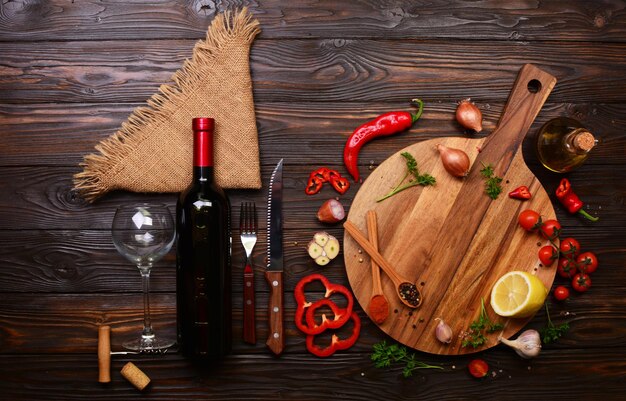 Épices et légumes et une bouteille de vin rouge