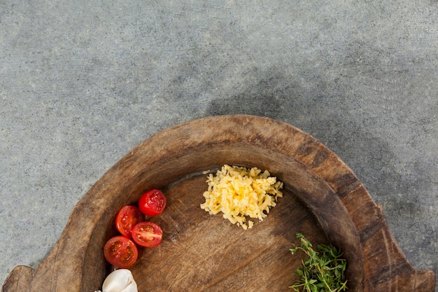 Épices et légumes dans un bol en bois