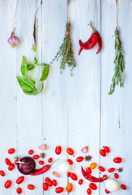 Épices et légumes sur fond de bois