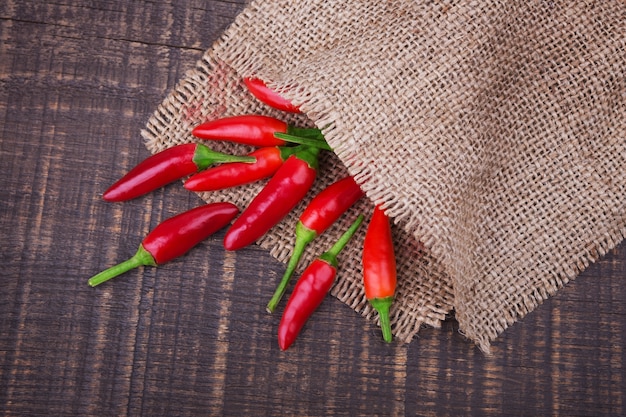 Épices de piment sur le sac. Sur une table en bois.