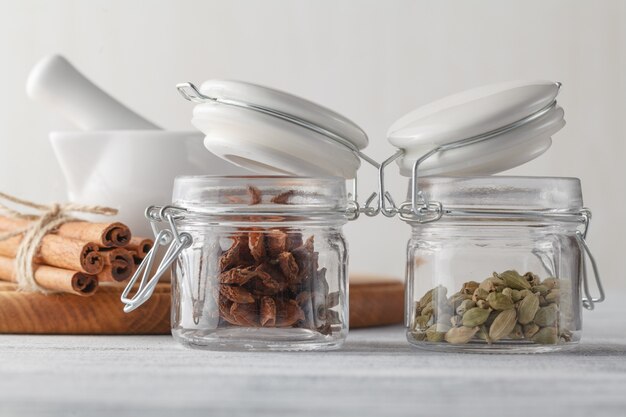 Épices en pots de verre sur une table en bois rustique