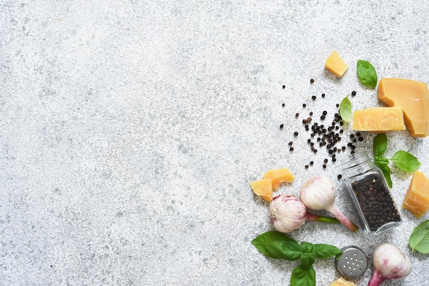 Épices pour cuisiner : parmesan, ail, basilic sur fond béton. Catégoriquement