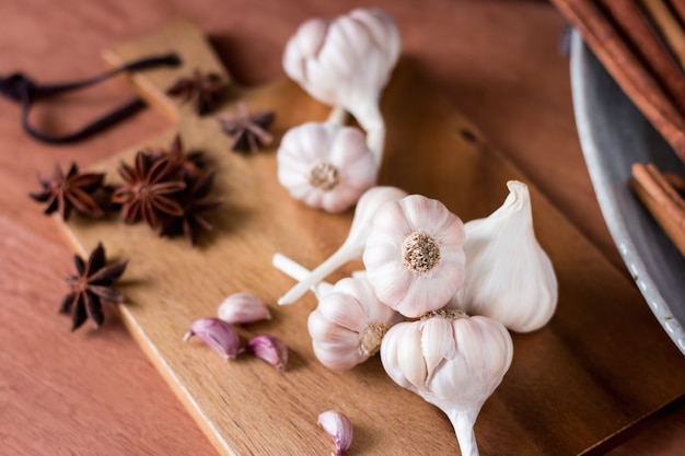 Épices sur la table en bois dans la cuisine. Contient de l&#39;ail blanc, de l&#39;anis étoilé et de la cannelle.