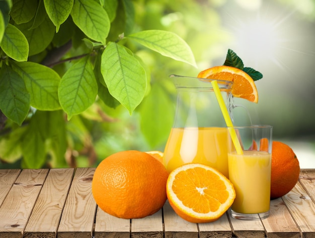 Pichet en verre de jus de fruits frais sur fond naturel