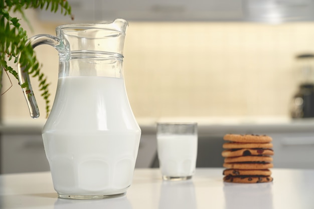 Photo pichet et verre de lait, délicieux biscuits américains.