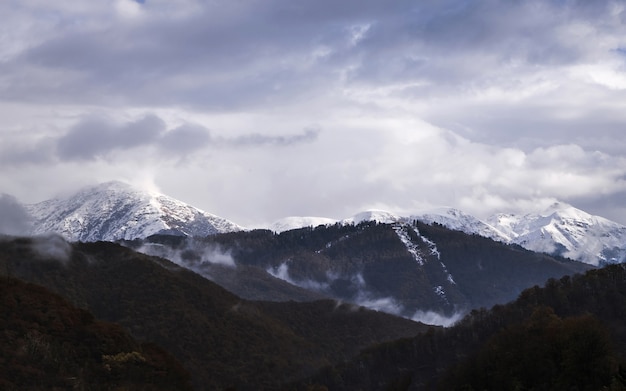 Pics enneigés des montagnes et ciel nuageux