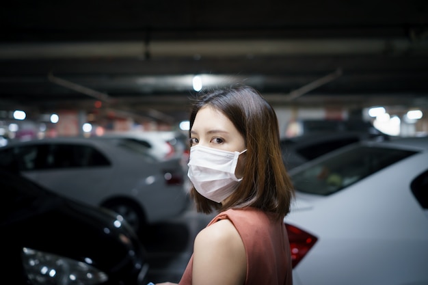 Épidémie de propagation de Covid-19. Femme au masque de protection médicale sur un parking. Peur du coronavirus.