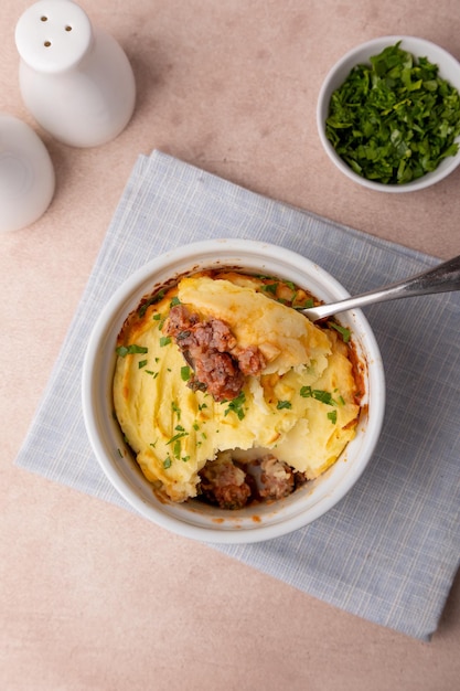 Photo pie de berger dans un plat de cuisson blanc portionné gratin de ragoût traditionnel fait maison avec de la viande hachée et de la purée de pommes de terre close-up de mise au point sélective