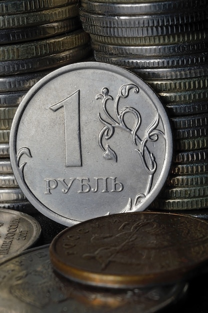 Pièce de 1 rouble russe (marche arrière) dans le contexte d'autres pièces pliées en colonnes.