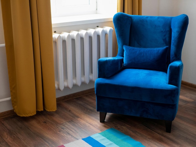 Photo une pièce du salon avec une fenêtre de fauteuil bleu et un rideau jaune, un sol en bois et un tapis rayé
