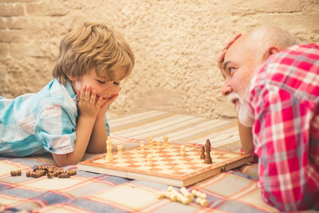 Photo pièce d'échecs concept grand-père et petit-fils beau grand-père et petit-fils jouent aux échecs pendant que s...
