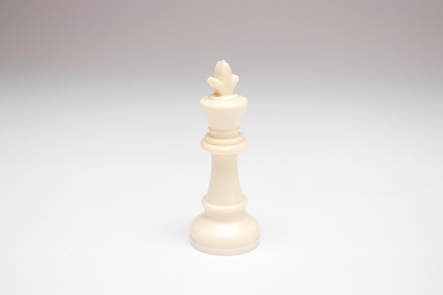 Pièce d'échecs du roi blanc sur fond blanc