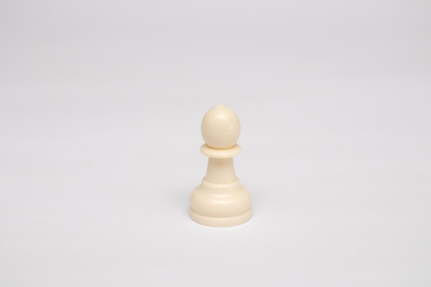 Pièce d'échecs pion blanc sur fond blanc.