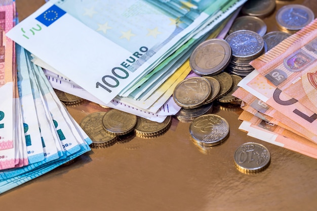 Pièce en euros et billets isolés sur l'or