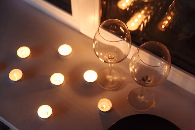 Pièce maîtresse de table de bougie romantique saisonnière concentrée à travers un verre de vin